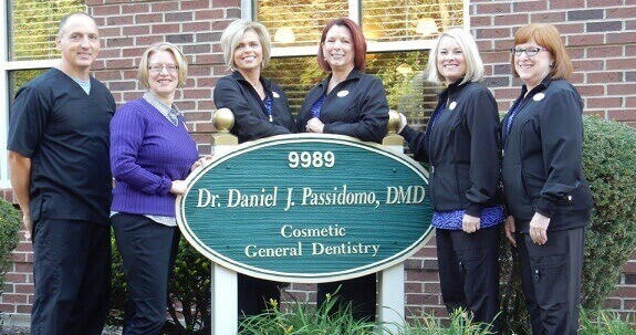 Dental team around exterior building sign of Daniel Passidomo, DMD in Centerville