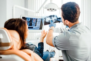 a dentist showing a patient their X-rays