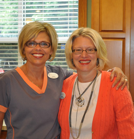 Two smiling women with arms around each other’s shoulders