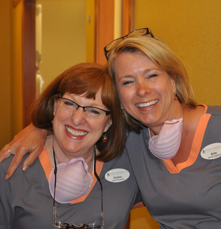 Two smiling dental team members