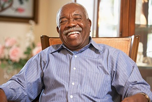 Man smiling brightly while sitting at home