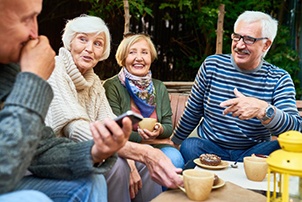 Group of friends laughing and eating breakfast on the patio
