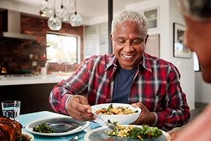 Senior man filling plate at table