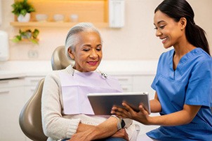 Patient and dental team member looking at tablet