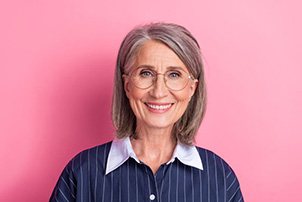 Portrait of happy, smiling senior woman against pink background