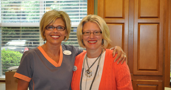 Two smiling dental team members