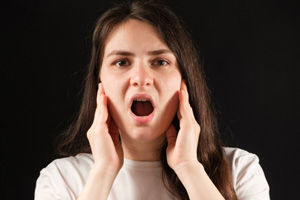 Symptoms of TMJ disorder include pain and stiffness in the jaw
