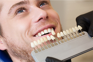 Man’s smile compared with tooth shading chart