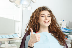 woman smiling giving thumbs up
