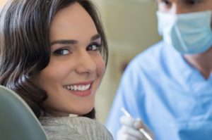 A woman smiling and learning about dental office safety.