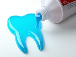 blue toothpaste coming out of tube in the shape of a tooth 