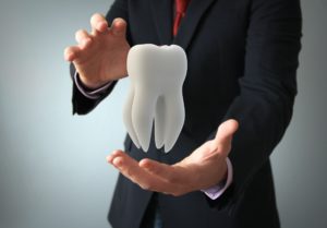 Dentist in Centerville holding a tooth.