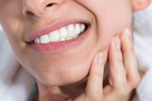 Woman with hand on face from dental pain